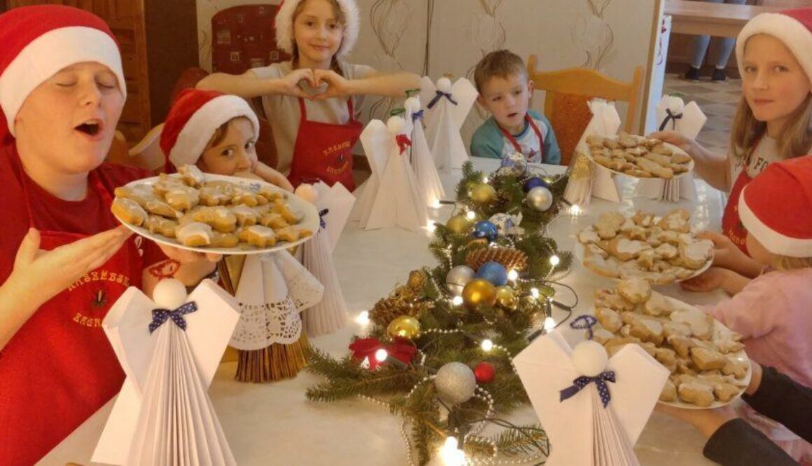Dzieci siedzą przy bożonarodzeniowym stole i jedzą pierniki w agroturystyce Pod Ptasią Górą